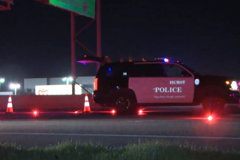 A Hurst police vehicle helps block traffic along Interstate 820 after a woman running in the...