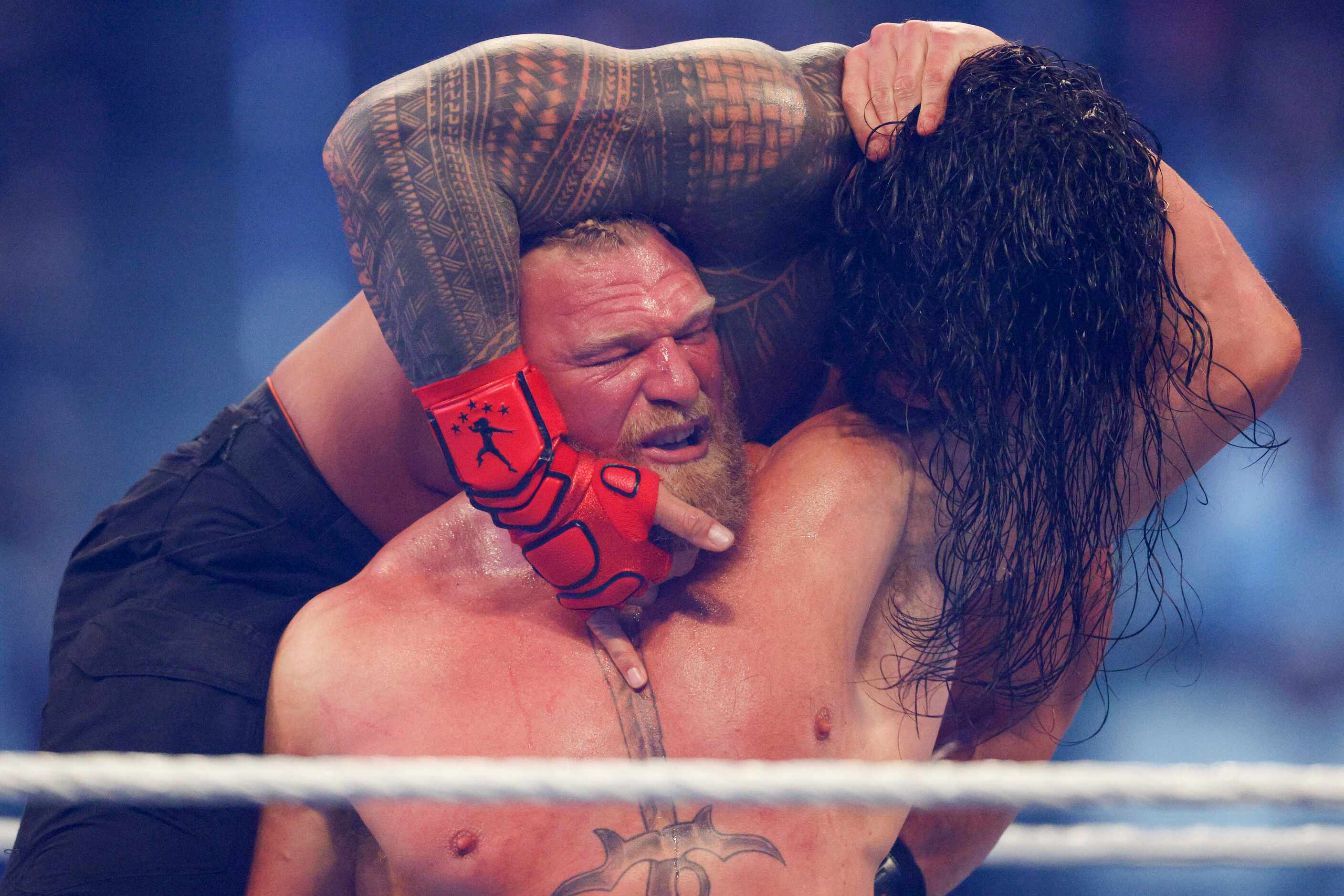 Brock Lesnar carries Roman Reigns during a match at WrestleMania Sunday at AT&T Stadium in...