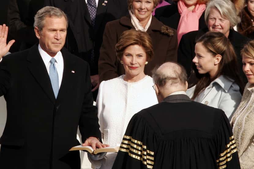 Chief Justice William Rehnquist delivers the oath of office as President George W. Bush is...