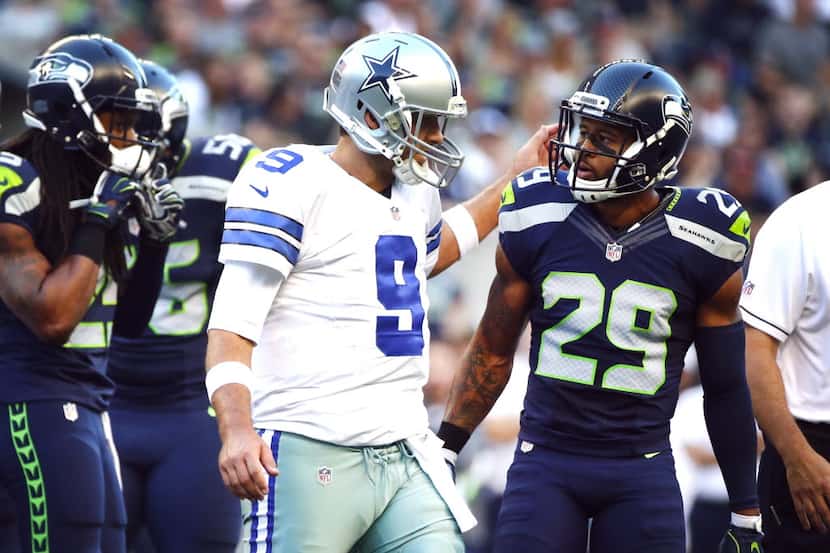 Seahawks free safety Earl Thomas talks with Cowboys quarterback Tony Romo as Romo comes off...