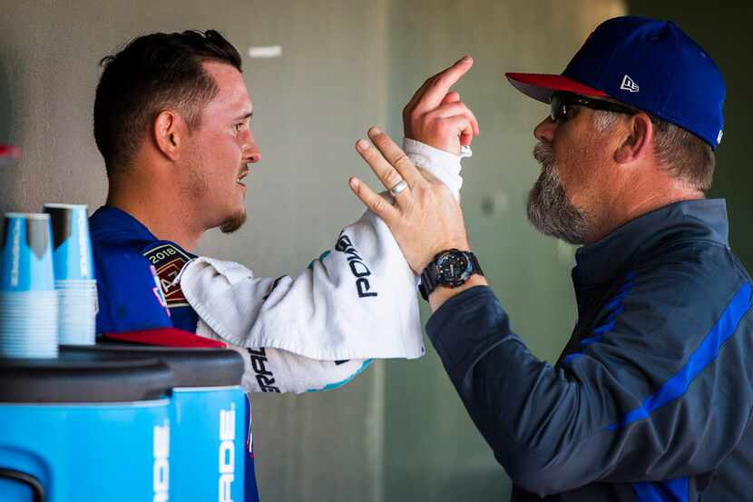 Texas Rangers pitcher Nick Gardewine works with pitching coach Doug Brocail in the dugout...