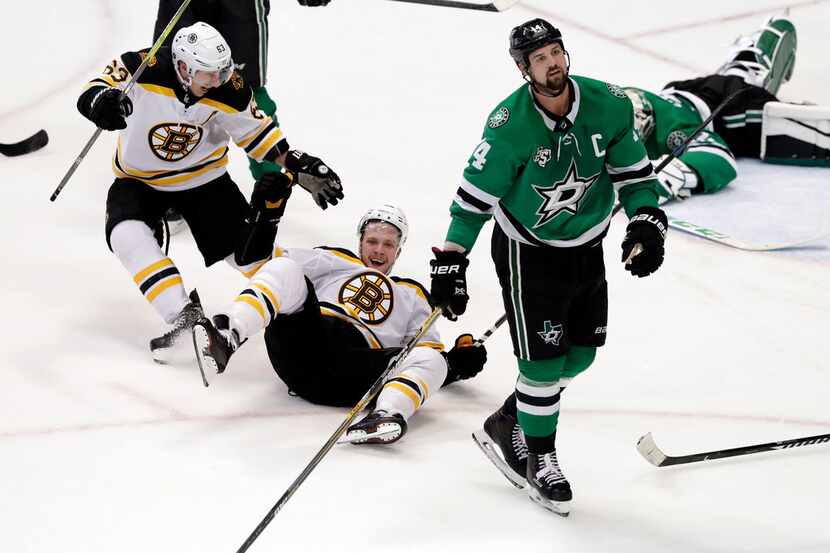 Boston Bruins' Brad Marchand (63) skates over to celebrate a goal with David Pastrnak,...