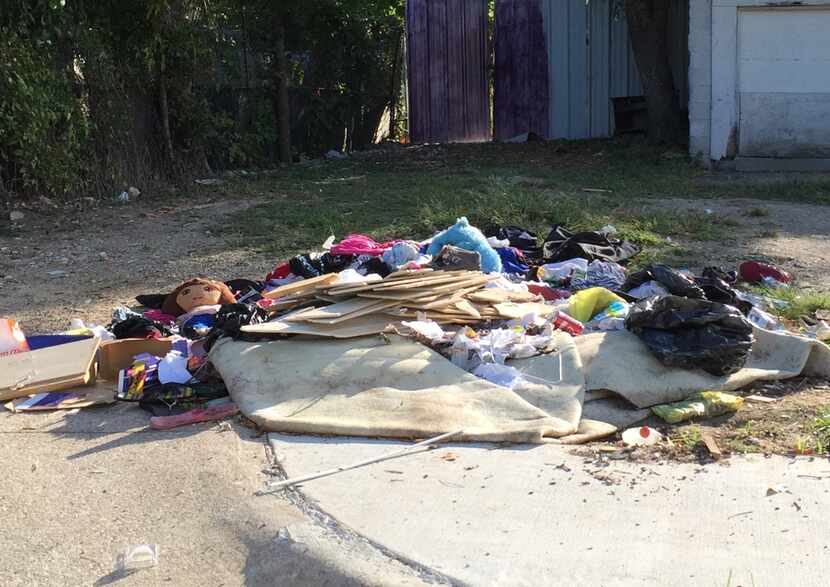 Trash and other debris litter a lot in the tidy Homestead neighborhood of homes in West...