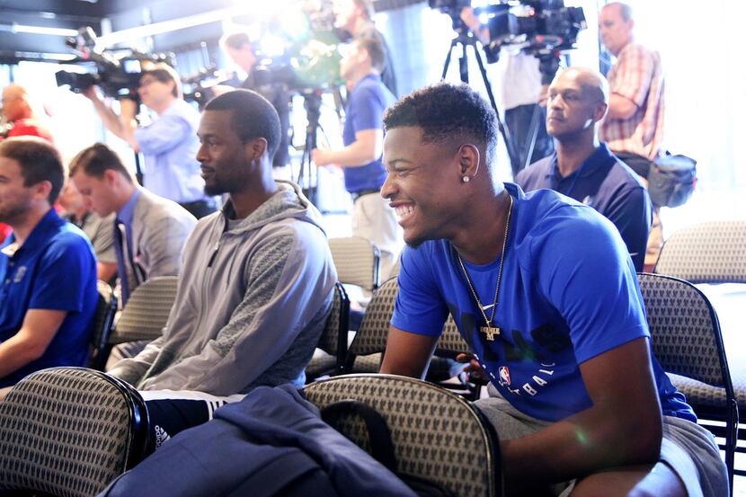 Dallas Mavericks players Harrison Barnes (center left) and Dennis Smith Jr. (right) watch...