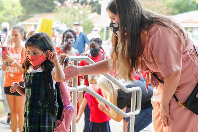 Chloe Serrato helps her daughter Clara, 5, into the first day of school at Arapho Classical...