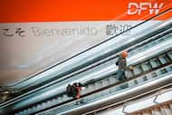 International connecting passengers ride an escalator at Terminal D at DFW Airport on...