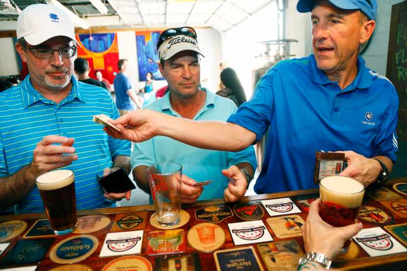 
Ken Staas, (from left) Jeff Duryea and Chuck Jaggers collect their beers at Four Bullets...
