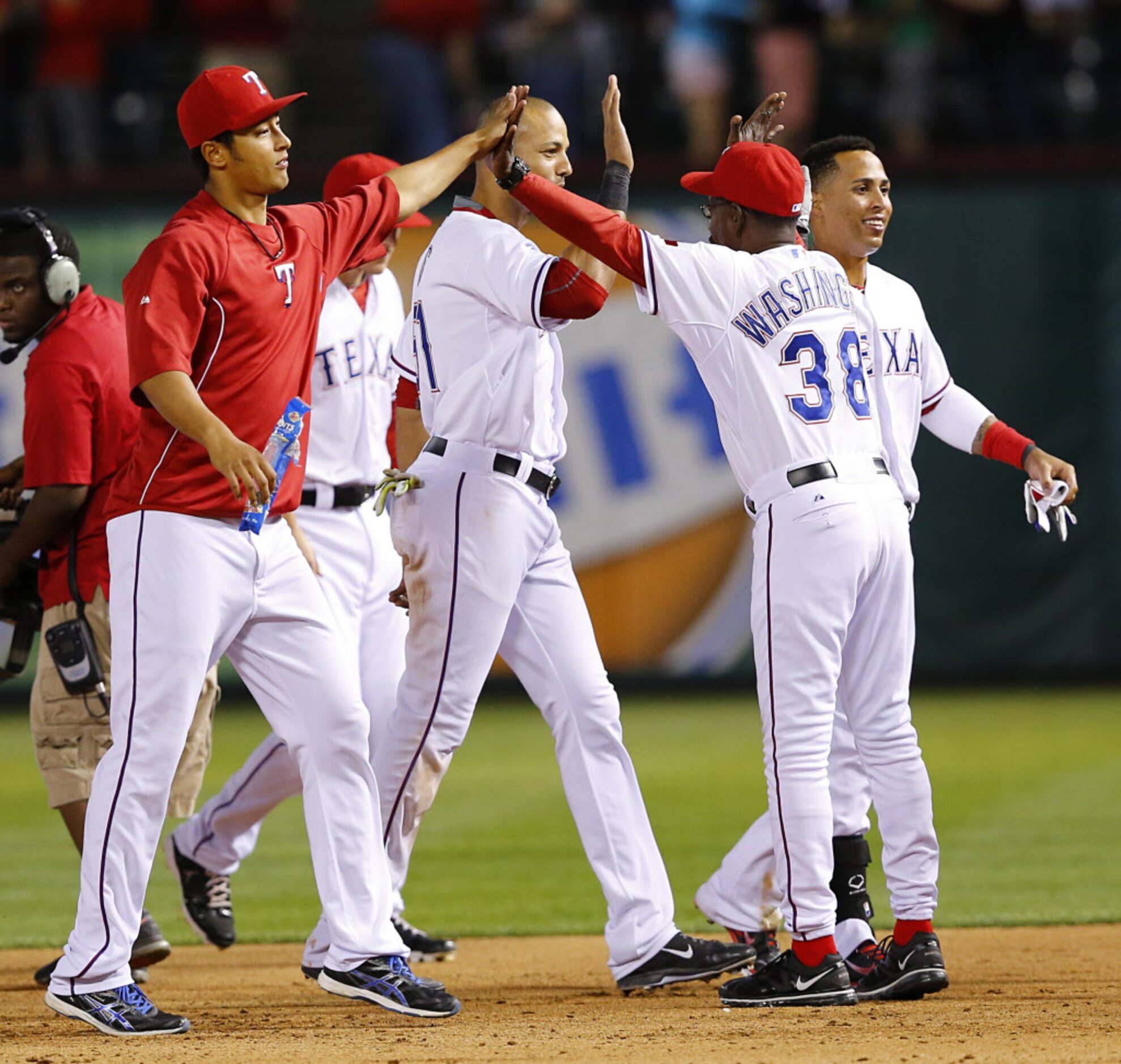 Texas Rangers manager Ron Washington (38) slaps hands with starting pitcher Yu Darvish (11)...