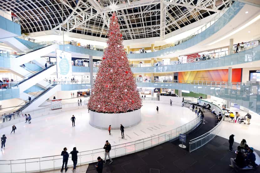 Skaters circle the 95-foot-high Christmas tree in the middle of Galleria Dallas' indoor ice...