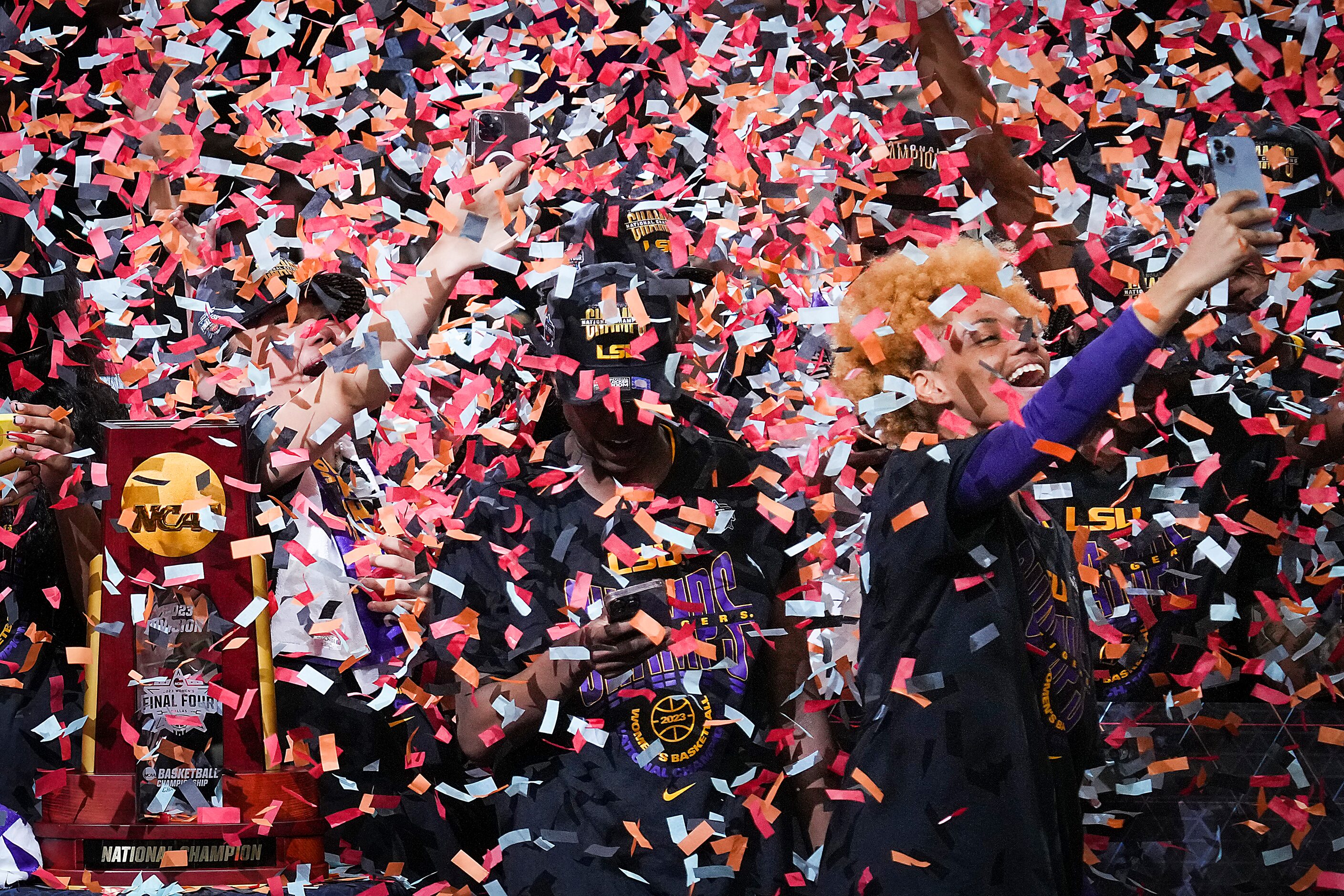 Confetti falls as LSU guard Jasmine Carson (right) takes a selfie while celebrating with the...