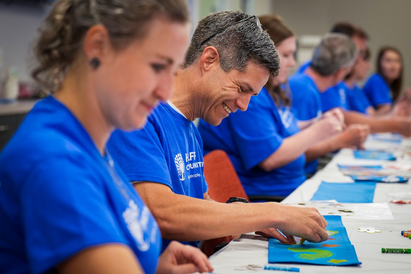 Todd Woodson joins teammates as the decorate and stuff duffle bags for foster children as...