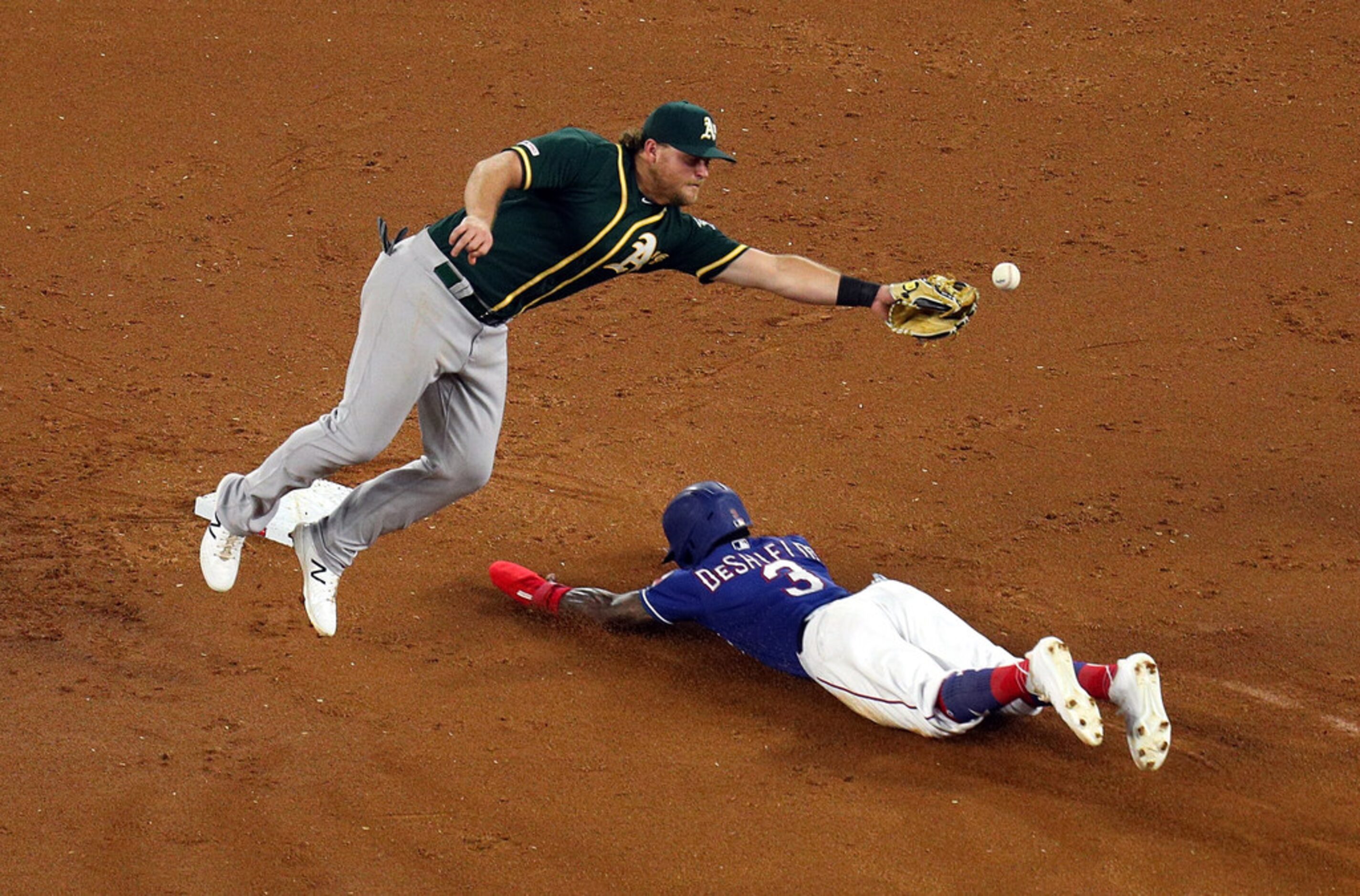 ARLINGTON, TEXAS - SEPTEMBER 14: Sheldon Neuse #64 of the Oakland Athletics misses the throw...