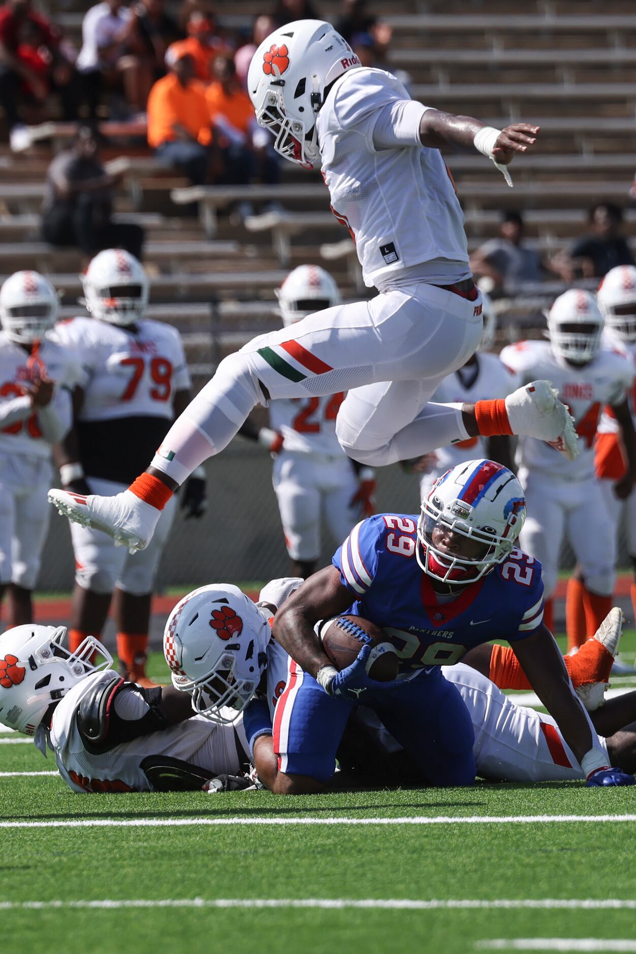 Jones High School Malik Bryant (0) jumps over Duncanville High School Caden Durham (29)...