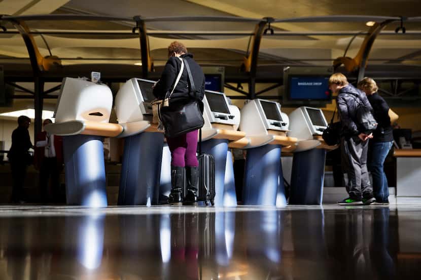 Passengers check in for Delta Air Lines flights at kiosks at Hartsfield-Jackson Atlanta...
