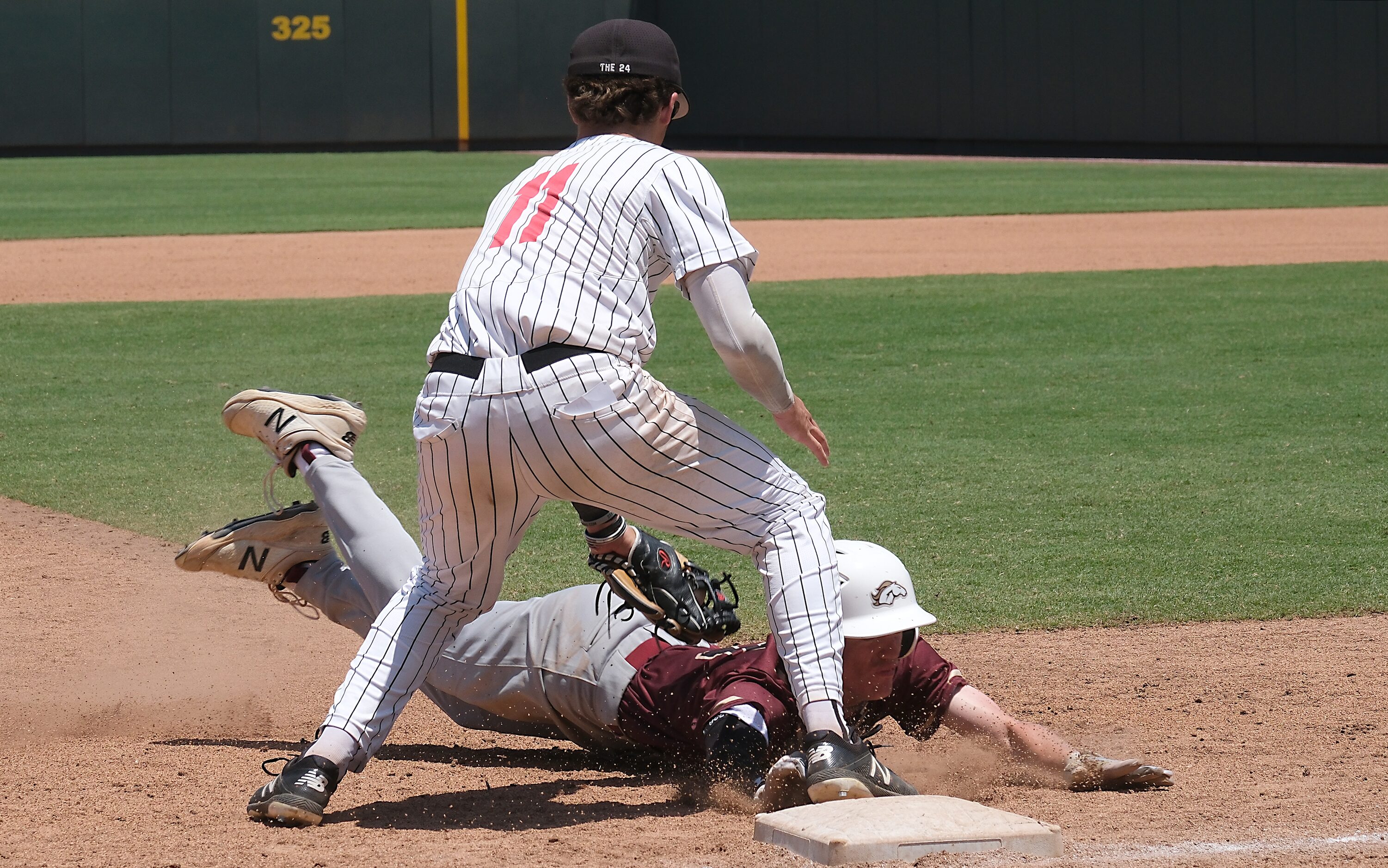 Argyle Micah Roberts, (11), tags out Magnolia West Cody Palacios, (4), at third base during...