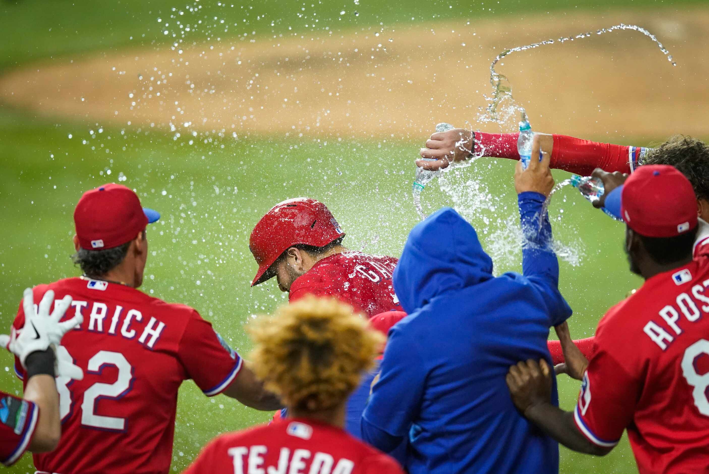 Texas Rangers right fielder Joey Gallo is mobbed by teammates after plating shortstop Isiah...