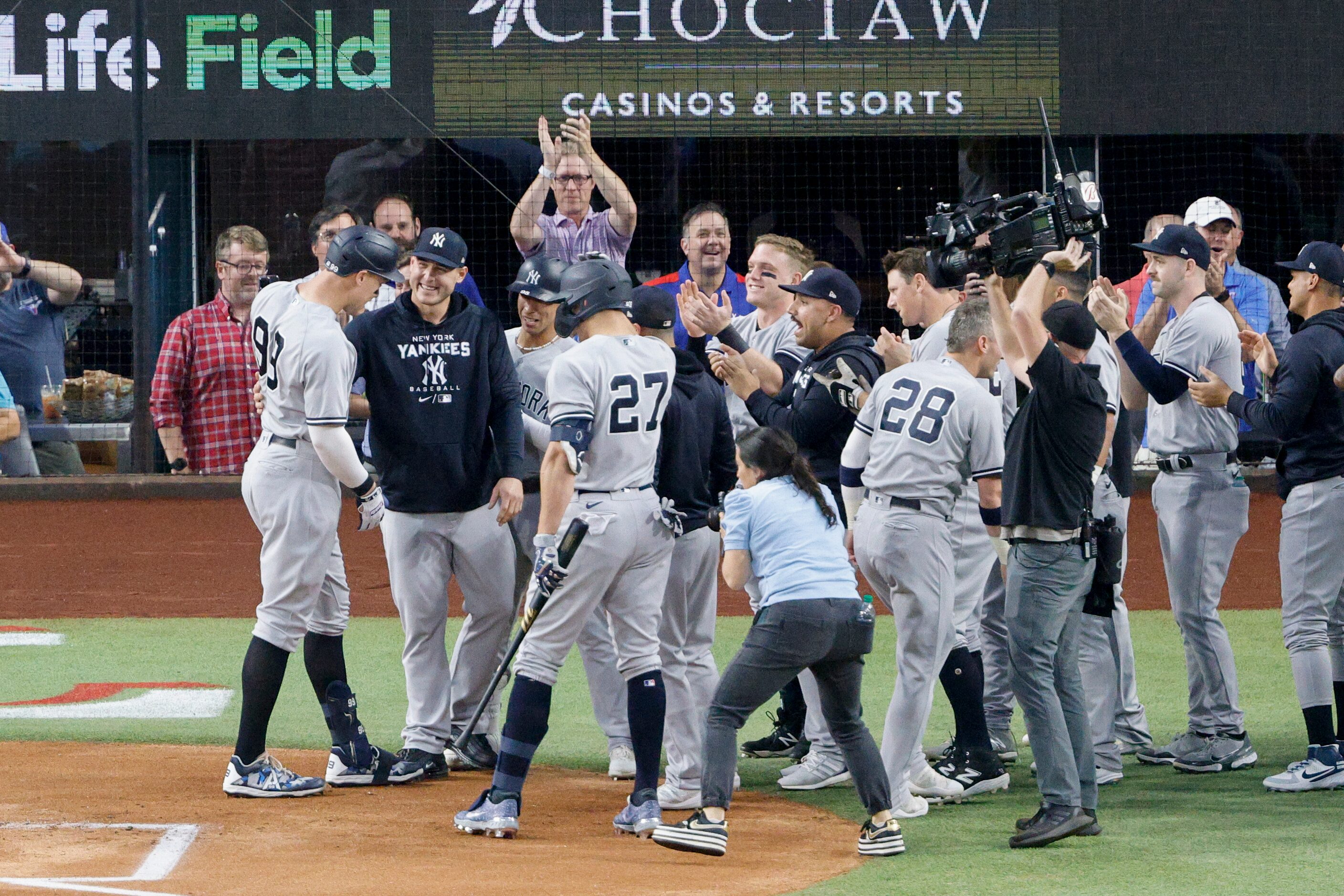 Members of the New York Yankees greet New York right fielder Aaron Judge (99) after he hit...