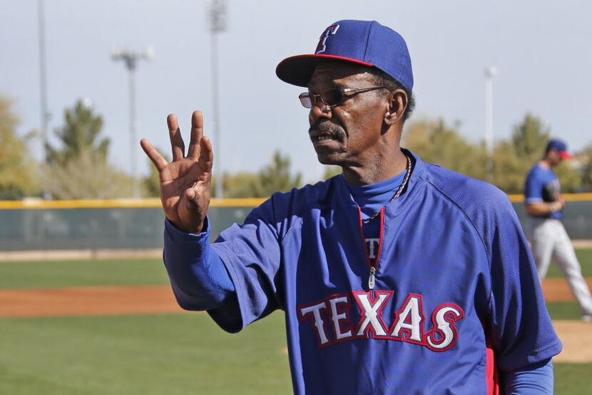 Texas manager Ron Washington tosses a ball as he demonstrates proper technique during a...