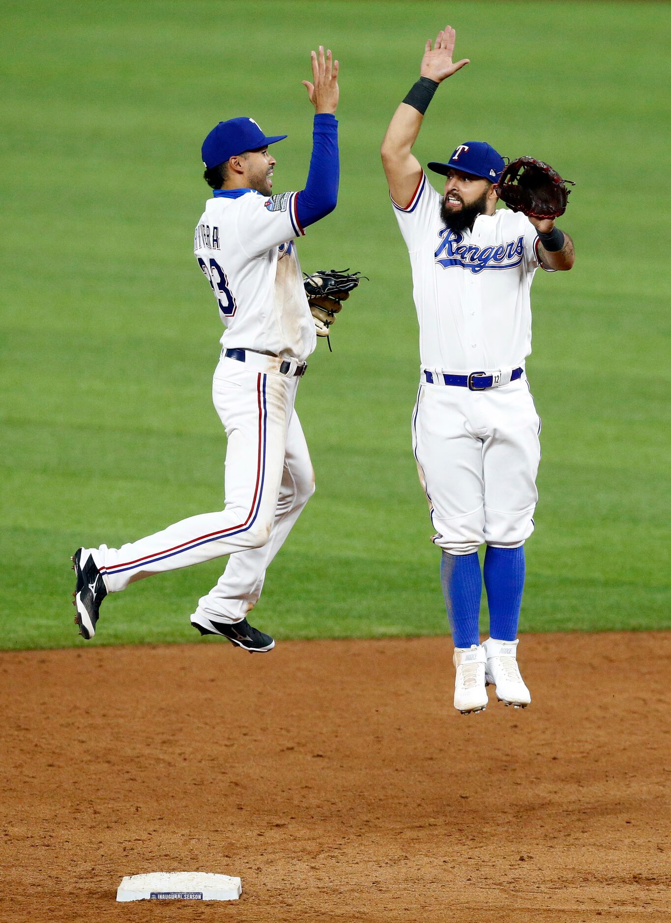 Texas Rangers infielders Yadiel Rivera (left) and Rougned Odor high five after the 3-2 win...