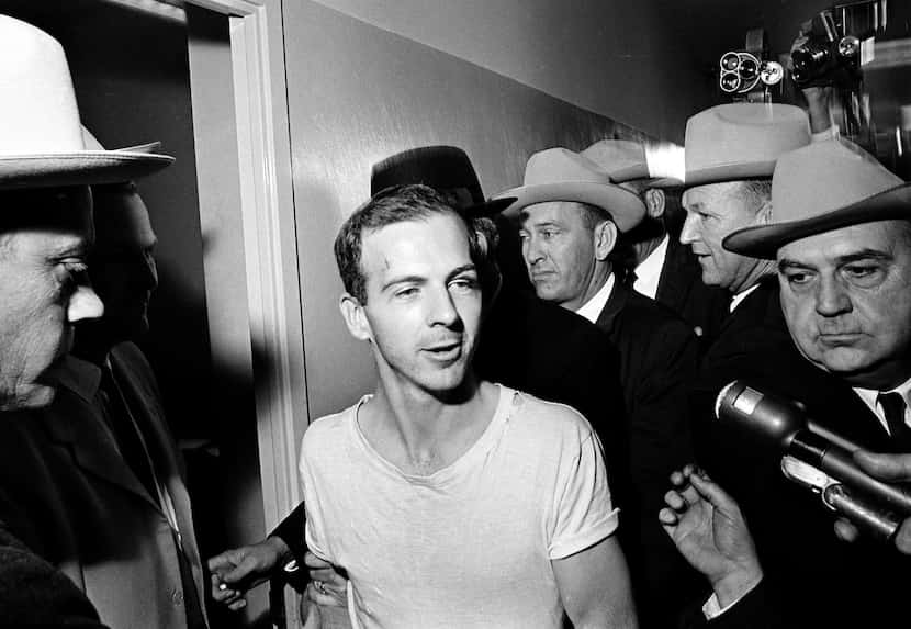 In this Nov. 23, 1963 file photo, surrounded by detectives, Lee Harvey Oswald talks to the...