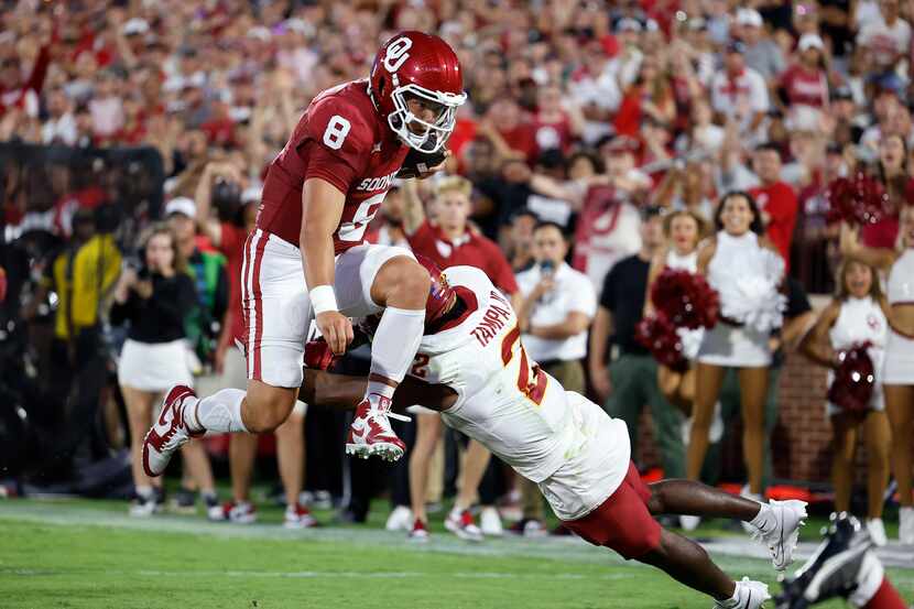 Oklahoma quarterback Dillon Gabriel (8) leaps past Iowa State defensive back T.J. Tampa (2)...