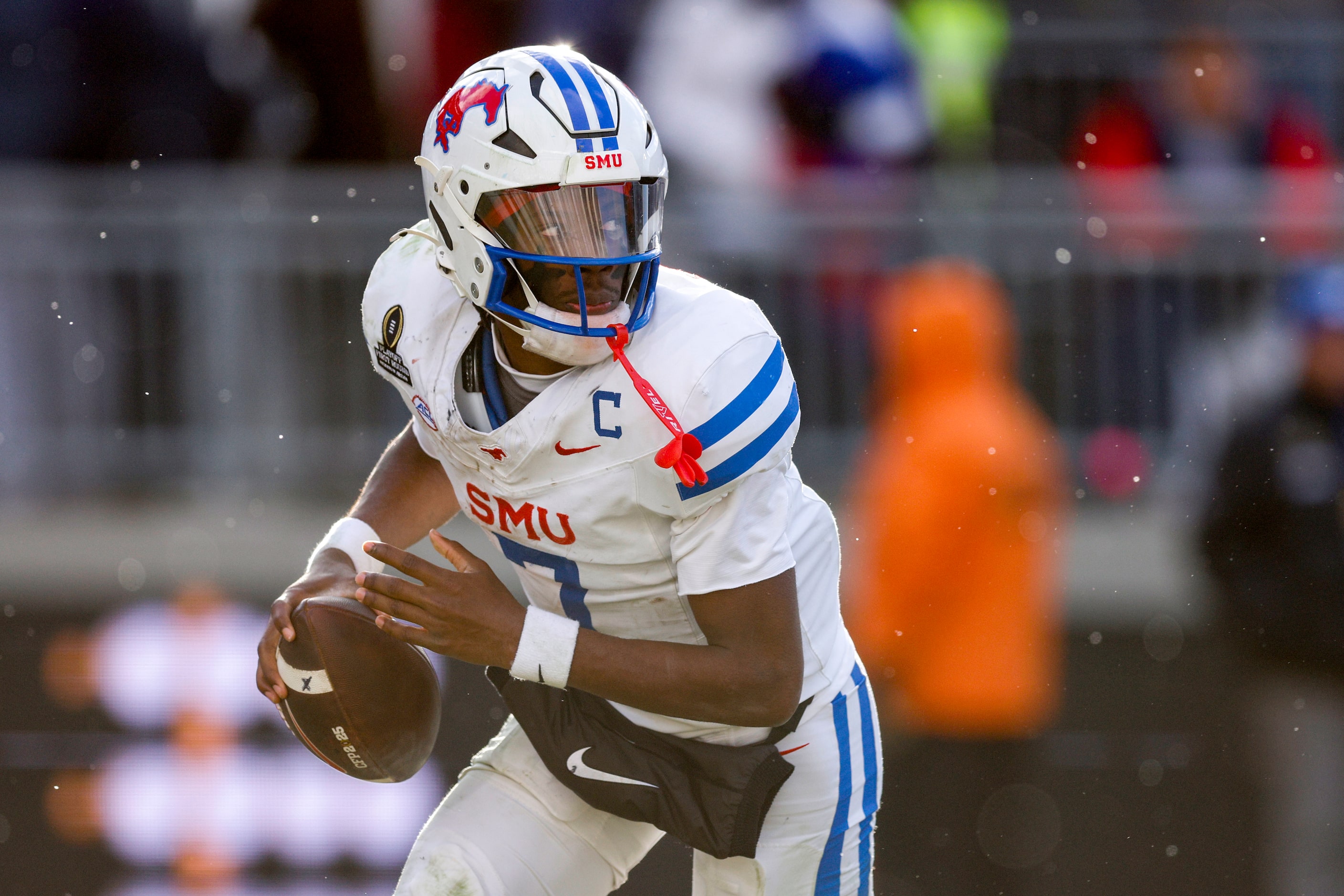 SMU quarterback Kevin Jennings (7) scrambles out of the pocket as he looks to pass during...