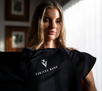 Jamie Nickerson holds a shirt she wore as a teller at Veritex Community Bank on Merrick...