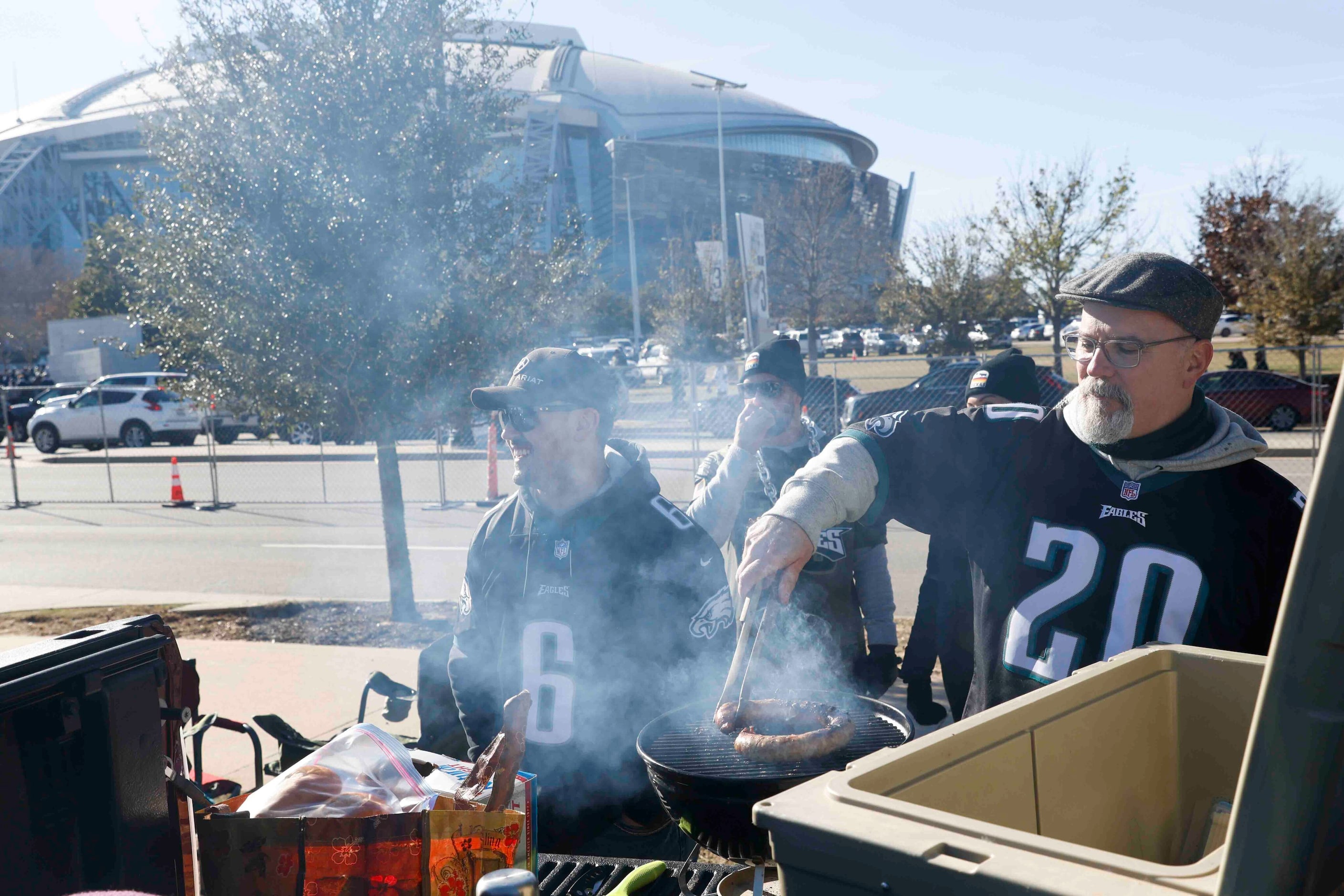 Tom Campbell, right, of Austin barbecues ahead of a NFL game between Dallas Cowboys and...