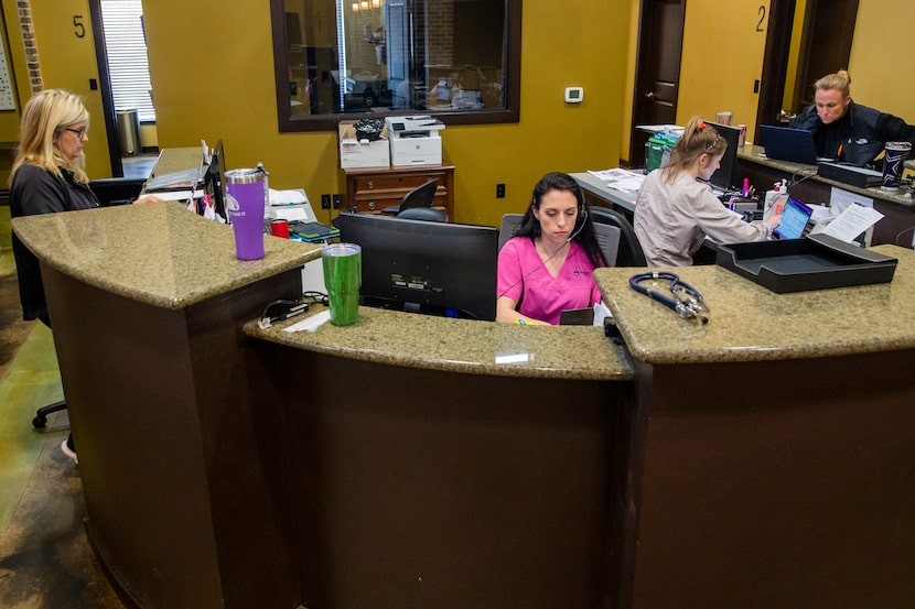 Lab manager LeaAnn Machado (center) and other medical staff employees work to coordinate...