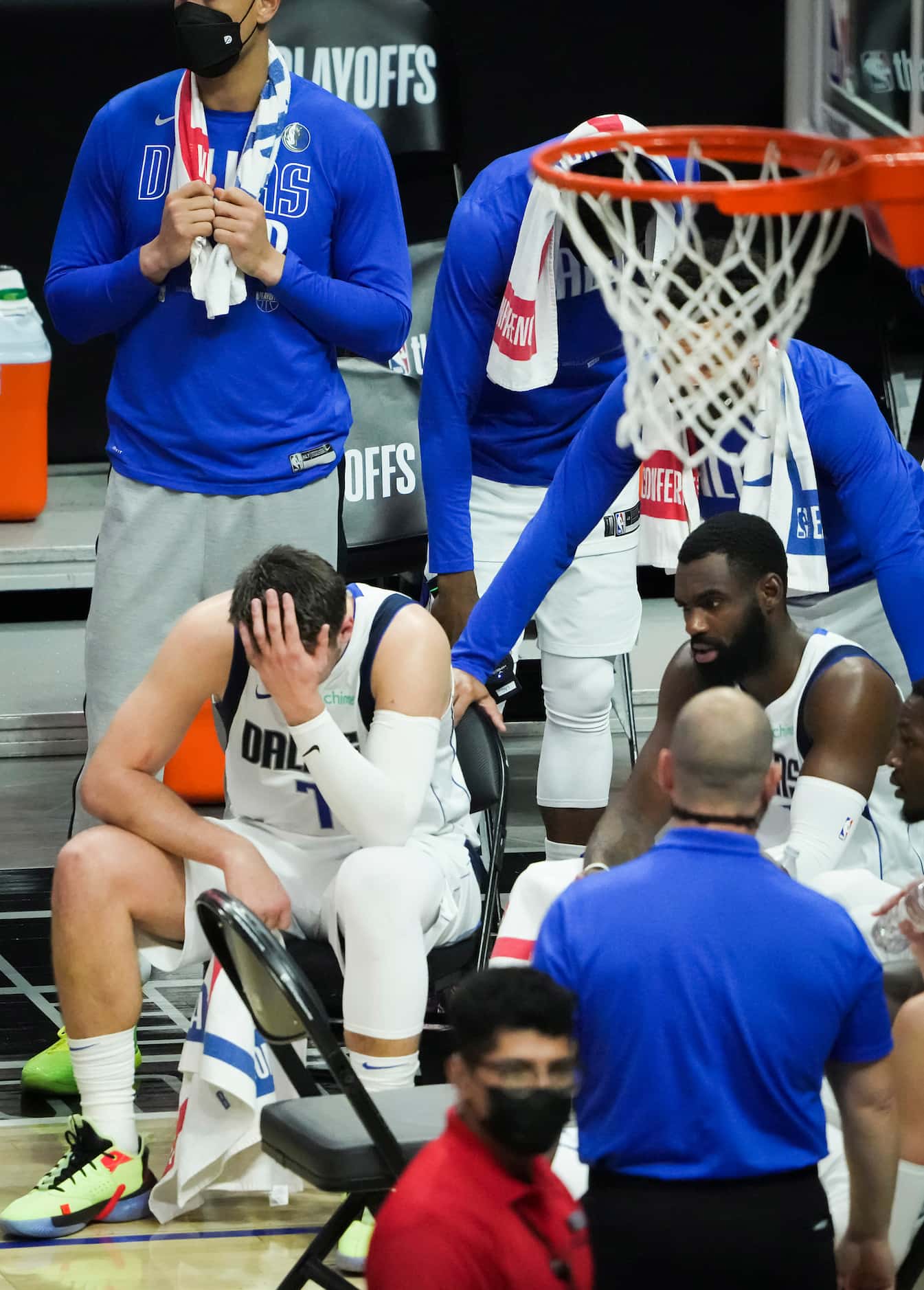Dallas Mavericks guard Luka Doncic (bottom left)  hangs his head during a timeout with...