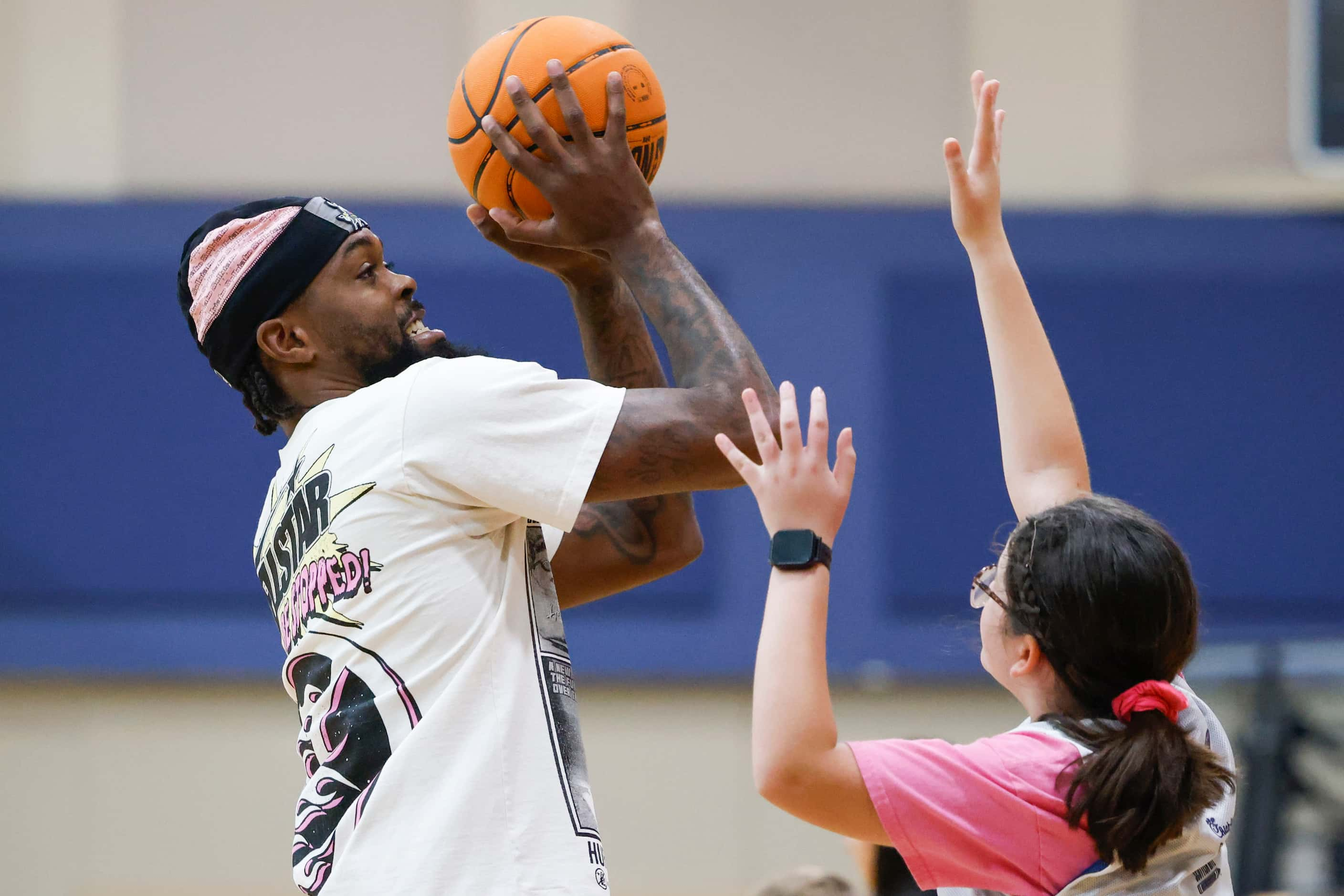 Dallas Mavericks’ Naji Marshall, play ball with young basketball campers during a Hoop Camp,...