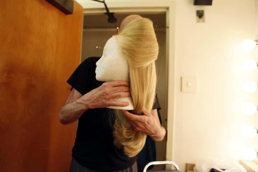 Coy Covington, hair-wig designer and makeup supervisor, enters a dressing room with a wig...