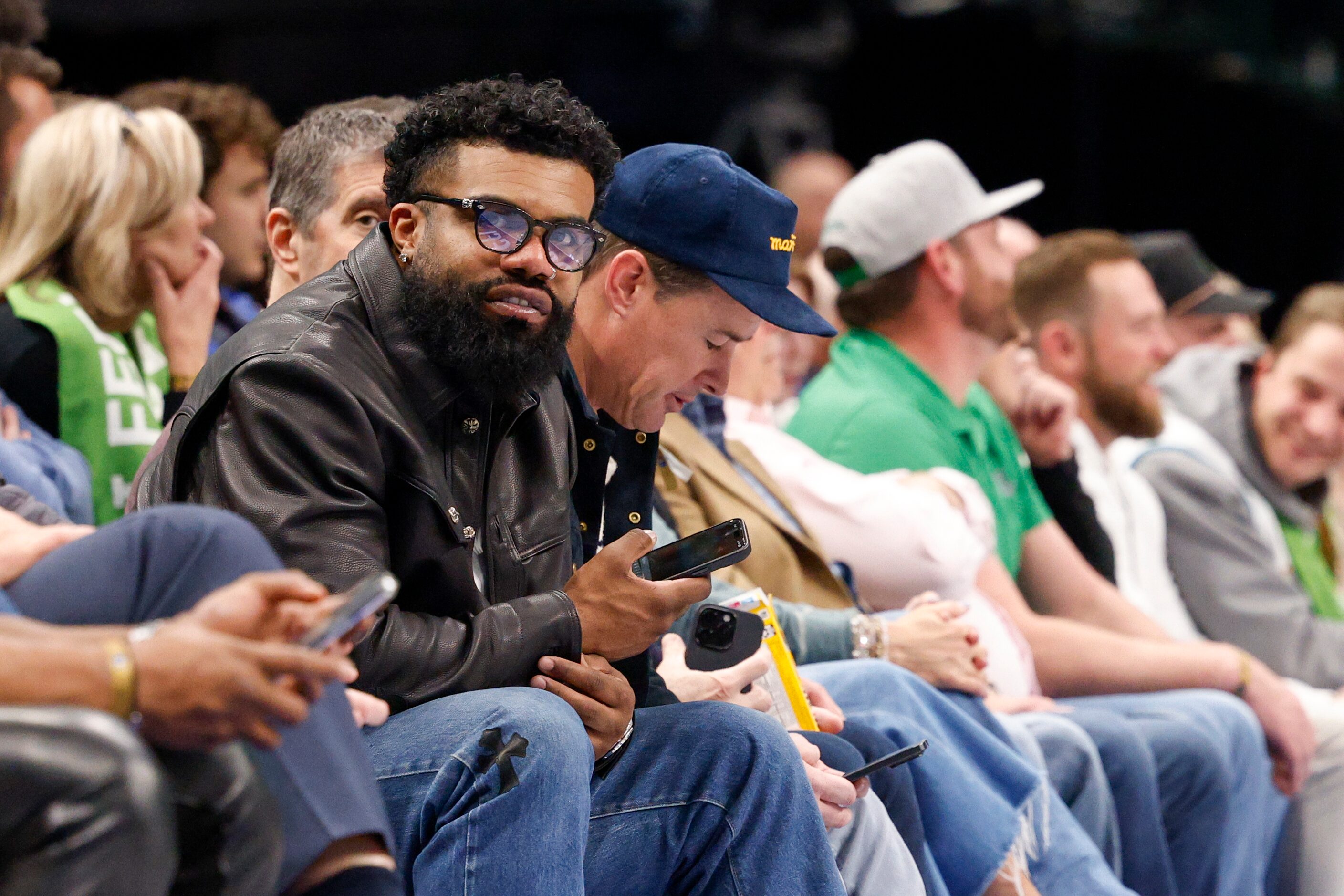 Former Dallas Cowboys running back Ezekiel Elliott watches the second half of an NBA game...