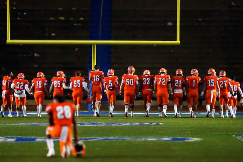 FILE - San Angelo Central football seniors walk hand-in-hand down the field one last time...