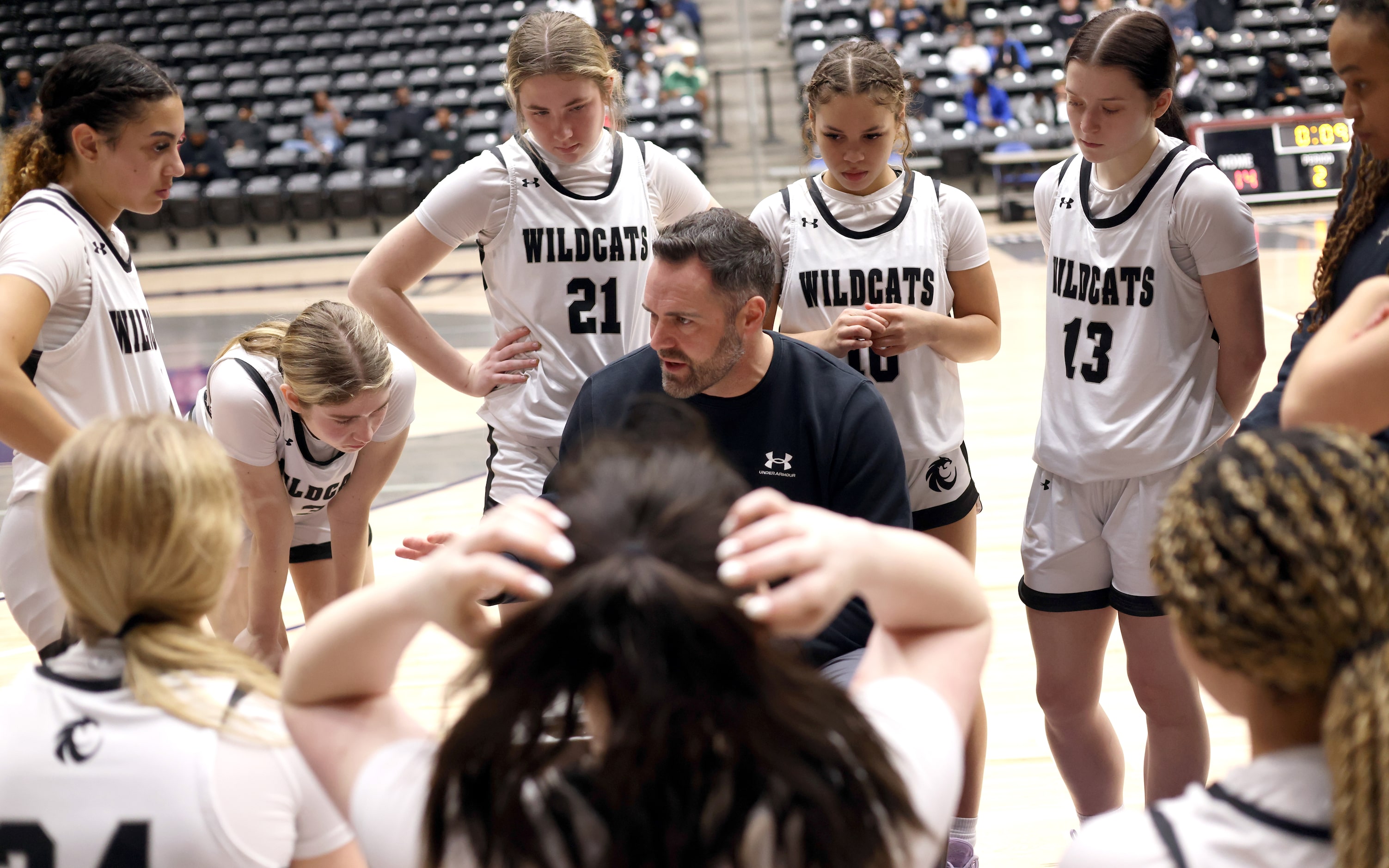 Denton Guyer head coach Jake Floyd, center, shares game strategy with his players during a...