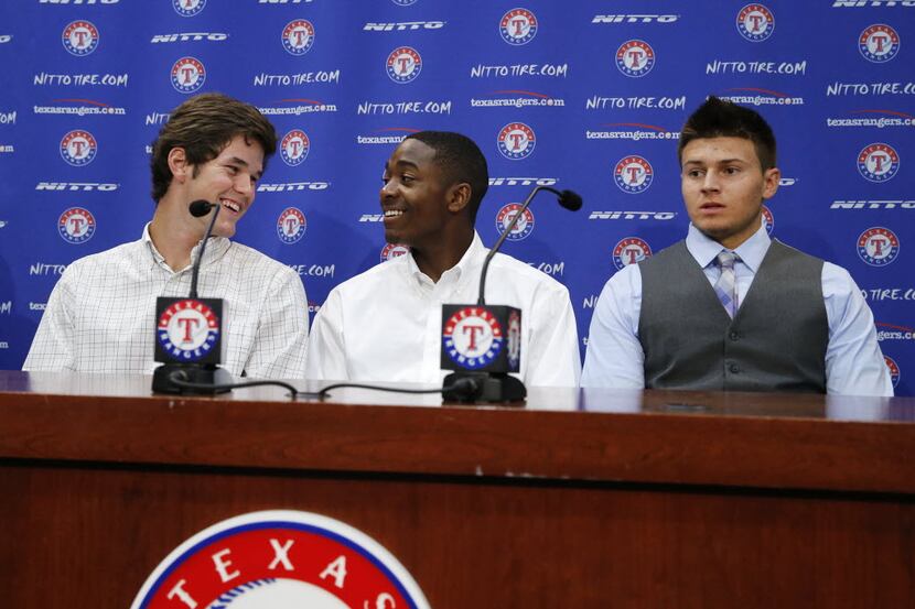 Texas Rangers Cole Ragans and Alex Speas laugh prior to the start of a press conference...