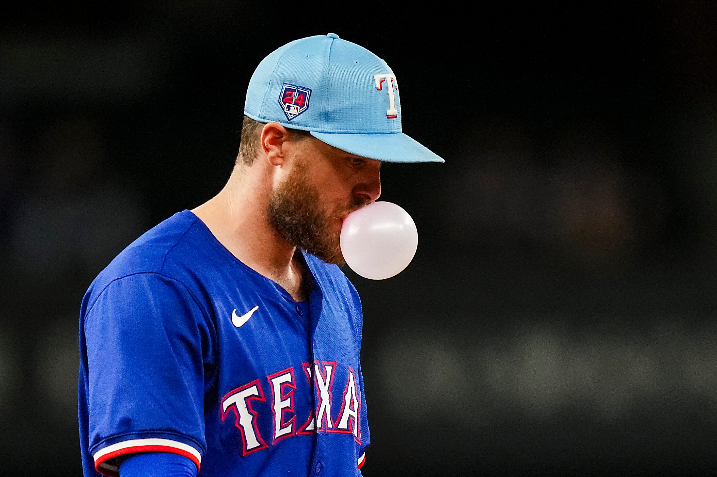 Texas Rangers infielder Jared Walsh blows a bubble between pitches during the fifth inning...