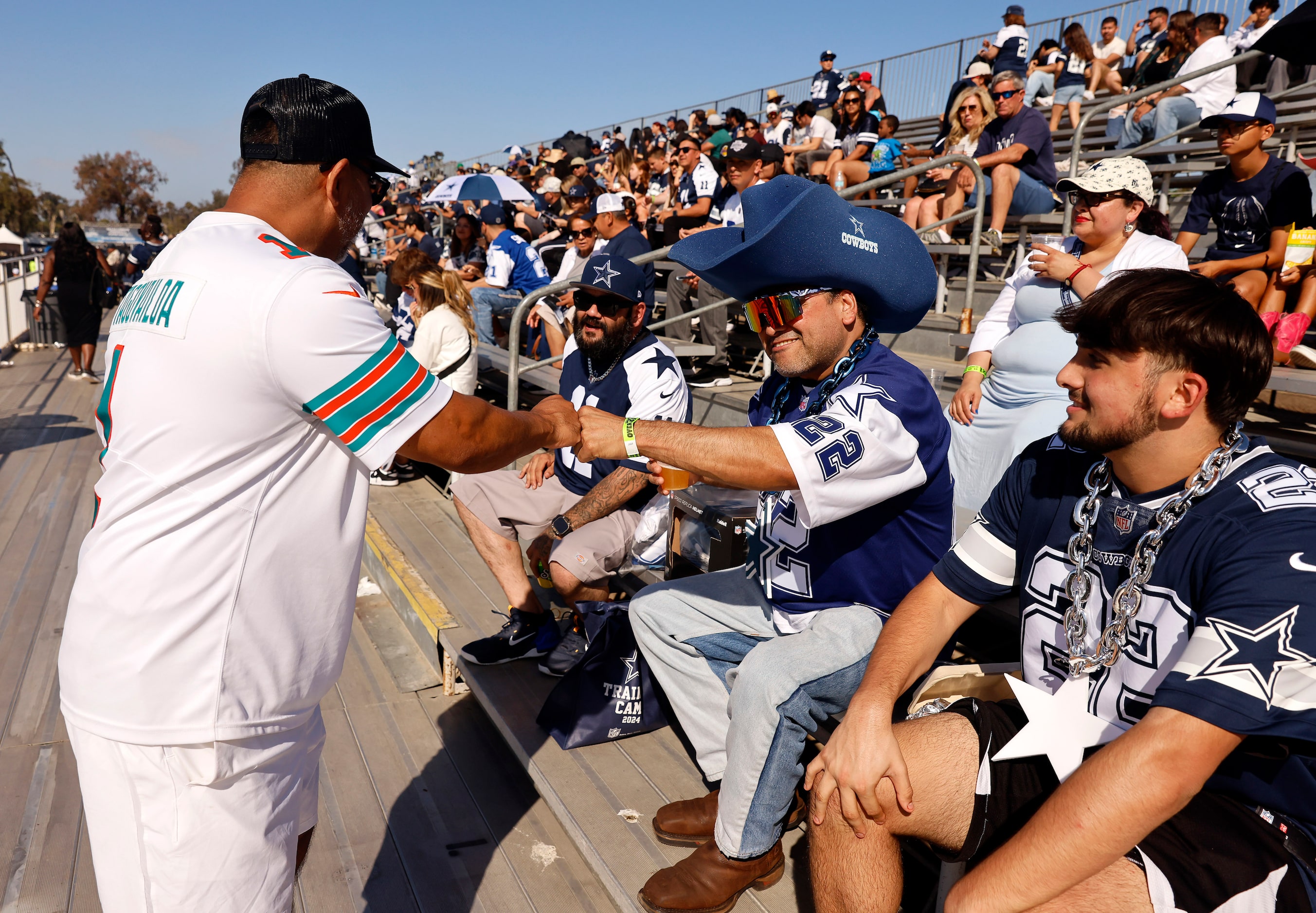 Miami Dolphins fans Rudy Sanchez of Camarillo, California (left) gives Manuel Madrigal of...