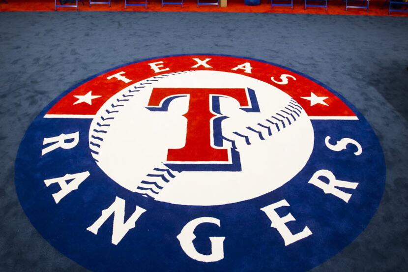 FILE - The team logo fills the center of the room in the clubhouse of the Texas Rangers...