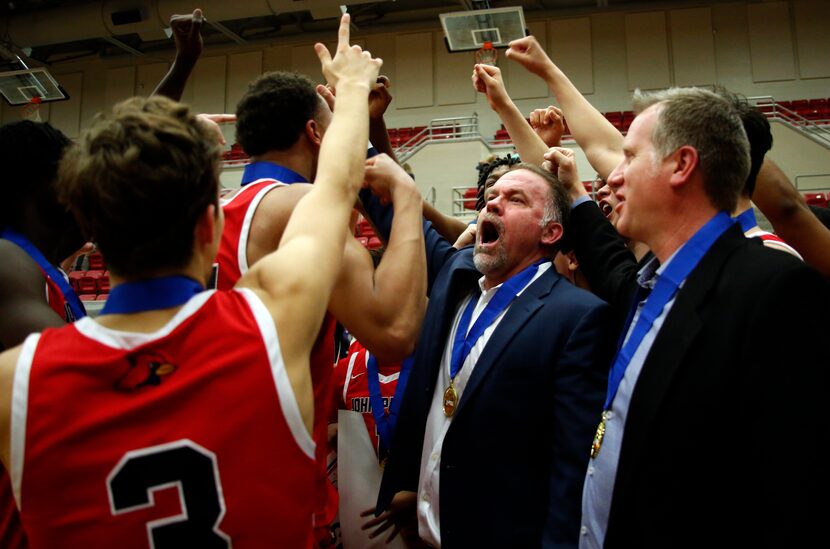 Plano John Paul ll head basketball coach Dan Lee, center, lets out a yell as he celebrates...