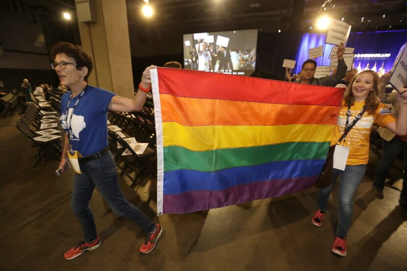 Members of the Texas Stonewall Democratic Caucus march across the floor during the Texas...