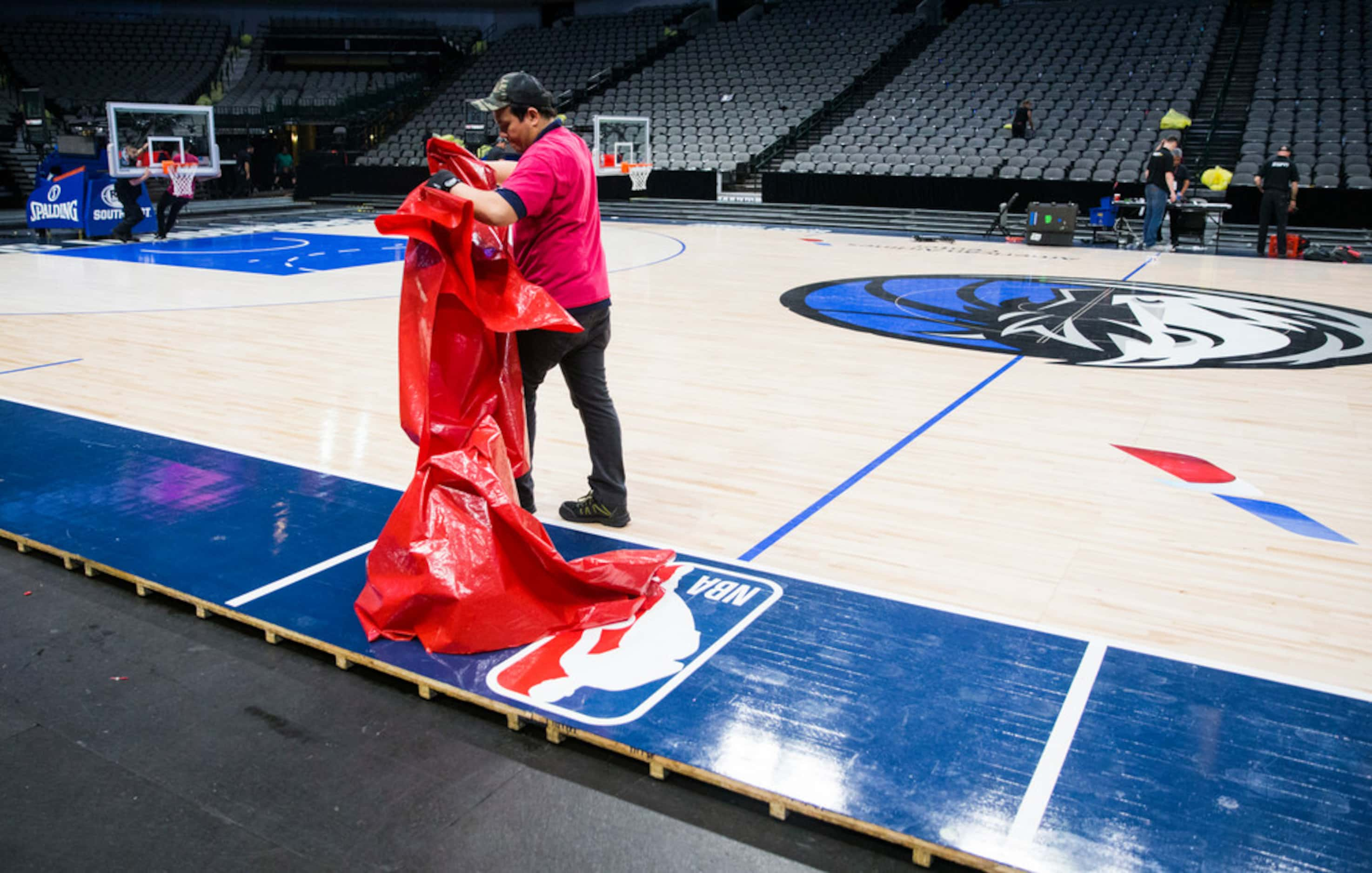 Crews break down the court after the Dallas Mavericks beat the Denver Nuggets 113-97 on...