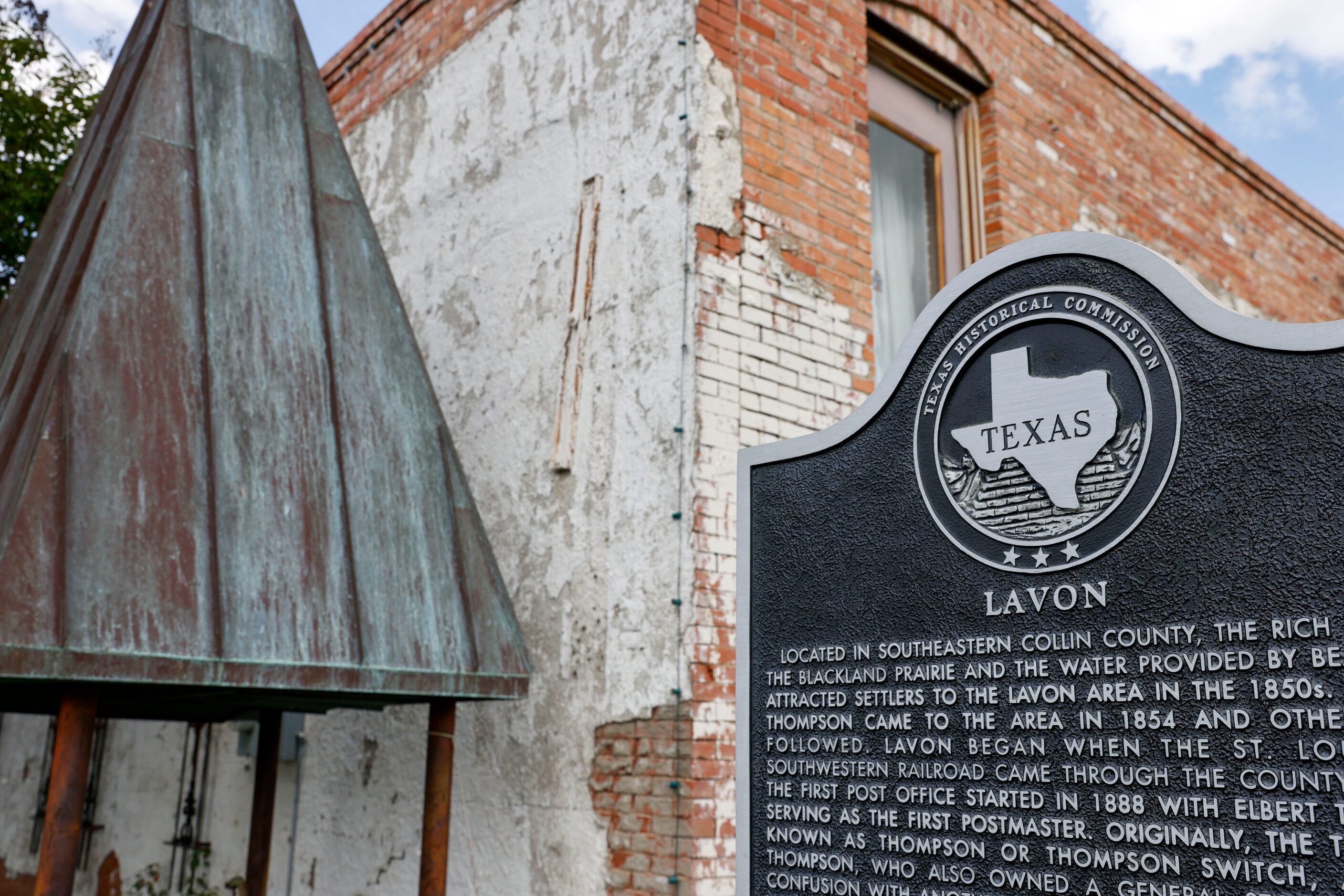 A historical marker for the city of Lavon sits near the Lavon State Bank building.