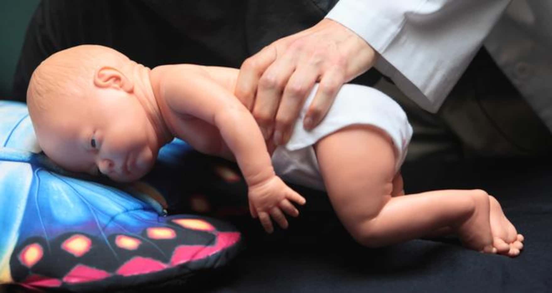 La doctora Wendy Gunther utiliza un muñeco para mostrar como un bebé puede morir si duerme...