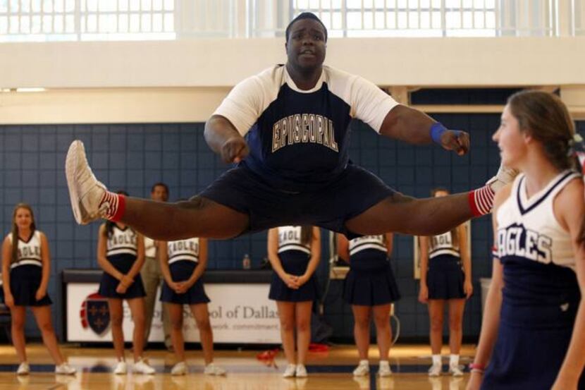 Episcopal School of Dallas' Armand Fernandez-Pierre, a cheerleader and football player jumps...