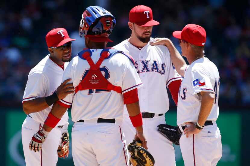 Apr 15, 2015; Arlington, TX, USA; Texas Rangers shortstop Elvis Andrus (L) talks with...