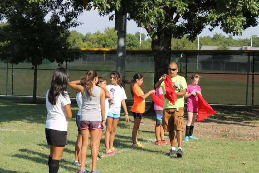 
J.L. Long Buccaneers soccer coach Victor Aves hands out practice jerseys to the girls on...