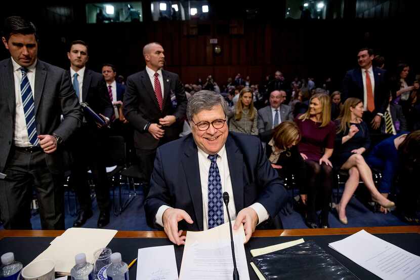 Attorney General nominee William Barr collects his papers as he departs for a lunch break...