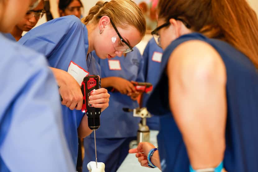 North Texas high schooler Emma Petteway is guided through drilling into a bone by Dr. Alex...