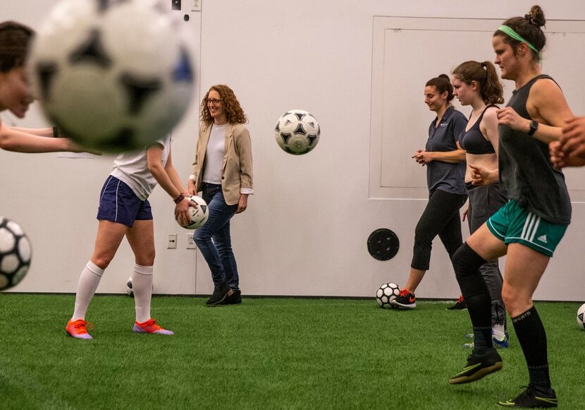 Director Wendy Dann walks by as the cast practices their soccer skills during a rehearsal...